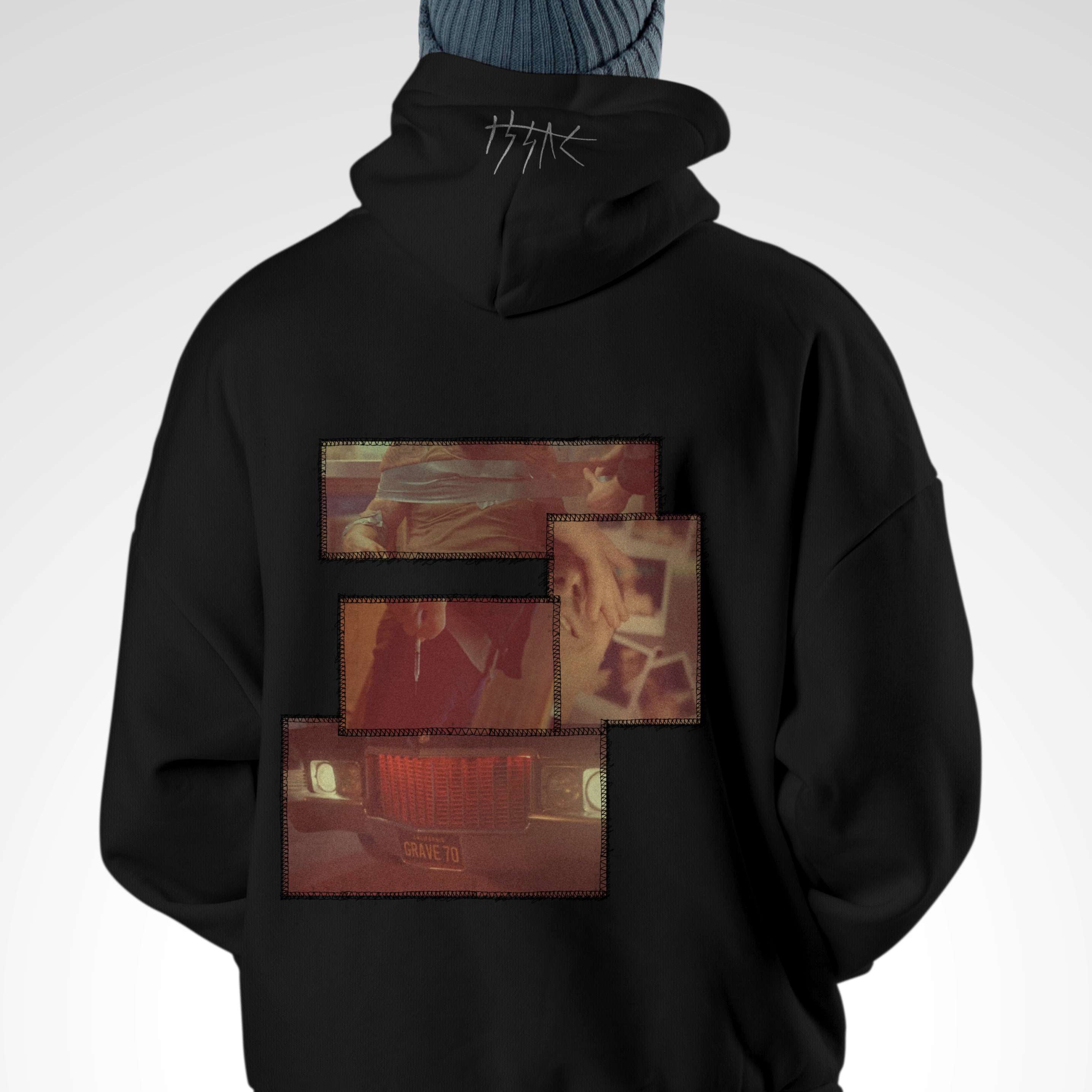 Person wearing a black hoodie with a graphic design on the back against a white background