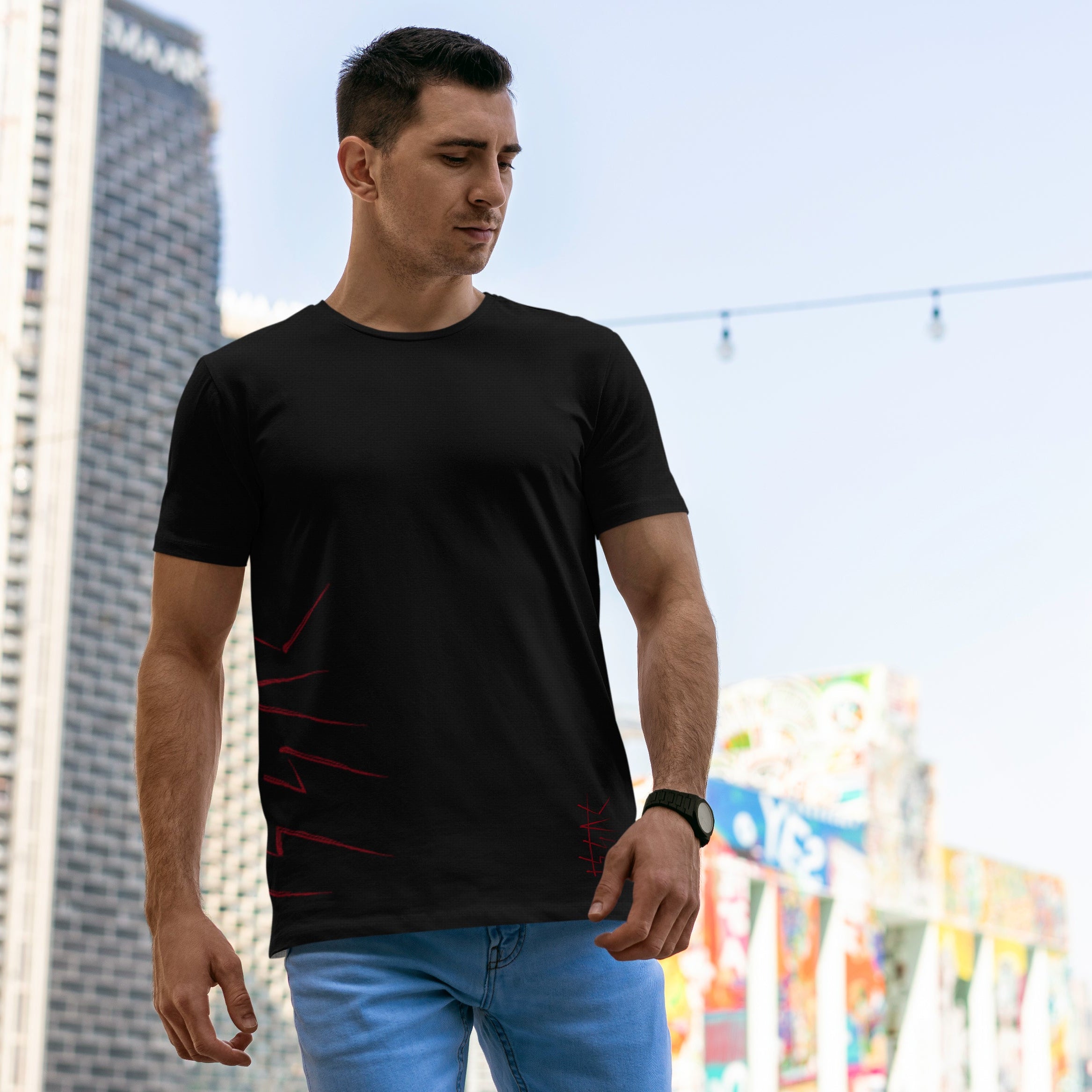 Man wearing a black t-shirt with red designs outdoors