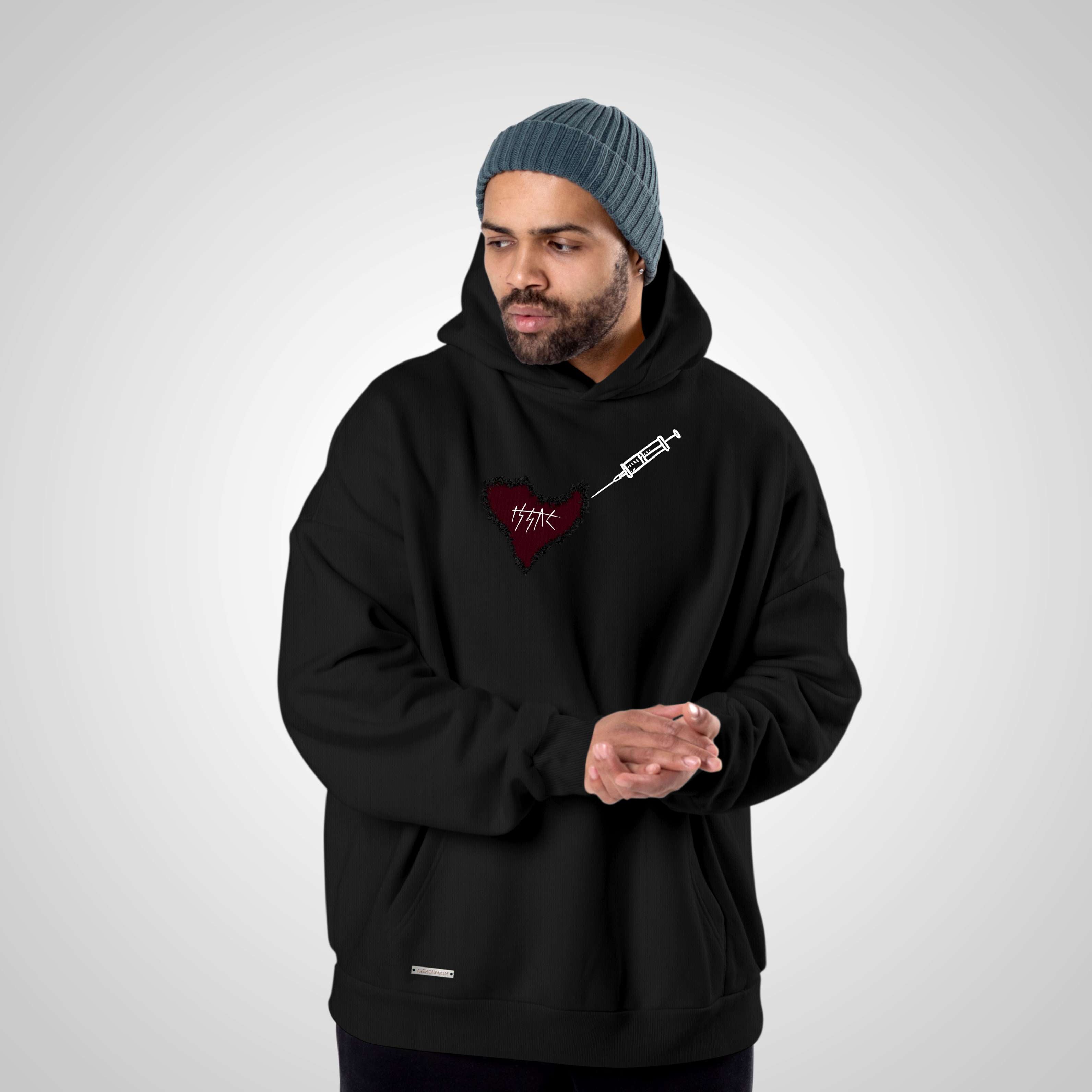 Person wearing a black hoodie with a logo on a gray background