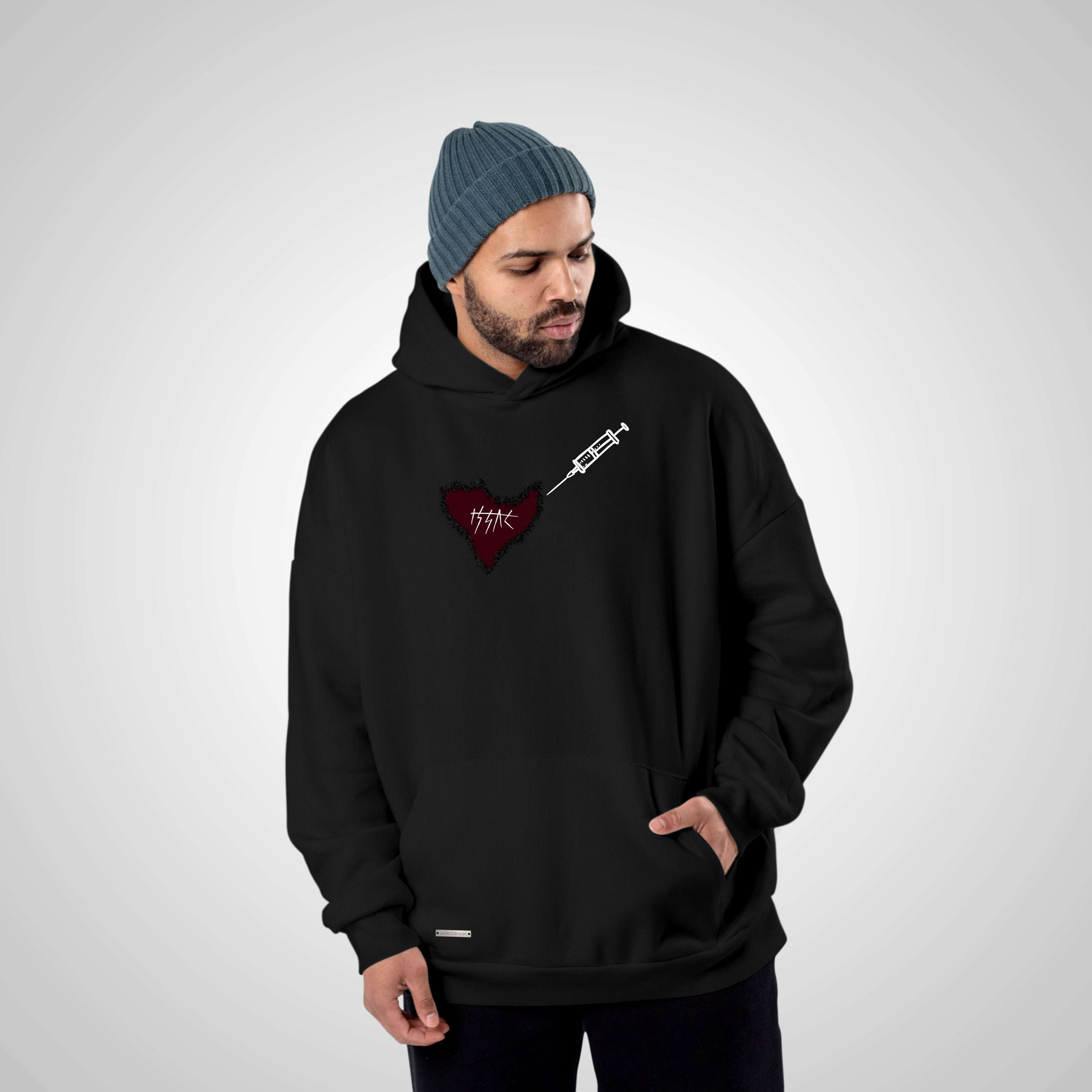 Person wearing a black hoodie with a red heart design on a gray background