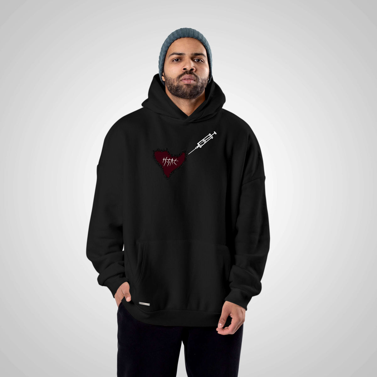 Man wearing a black hoodie with a red heart design on a gray background