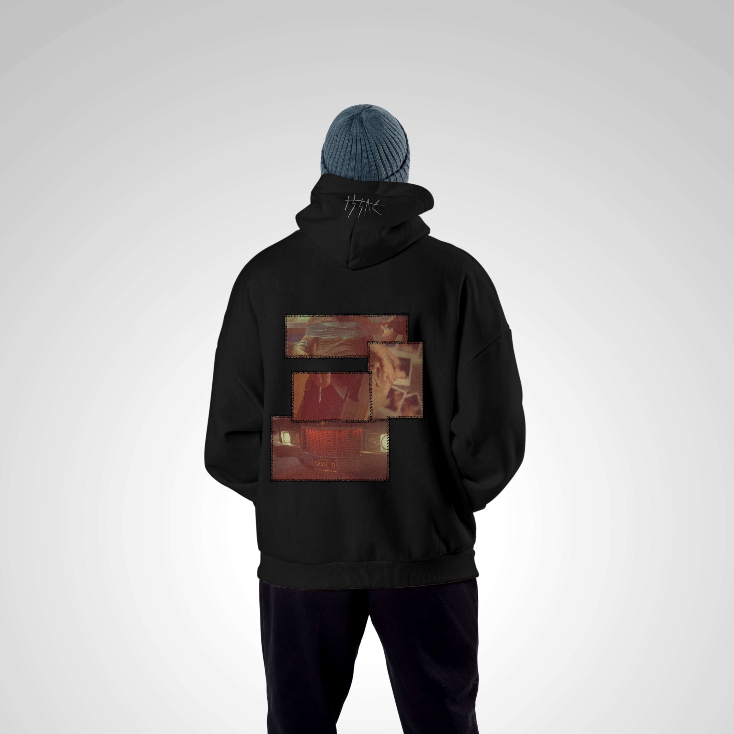 Person wearing a black hoodie with a unique design on the back against a light gray background